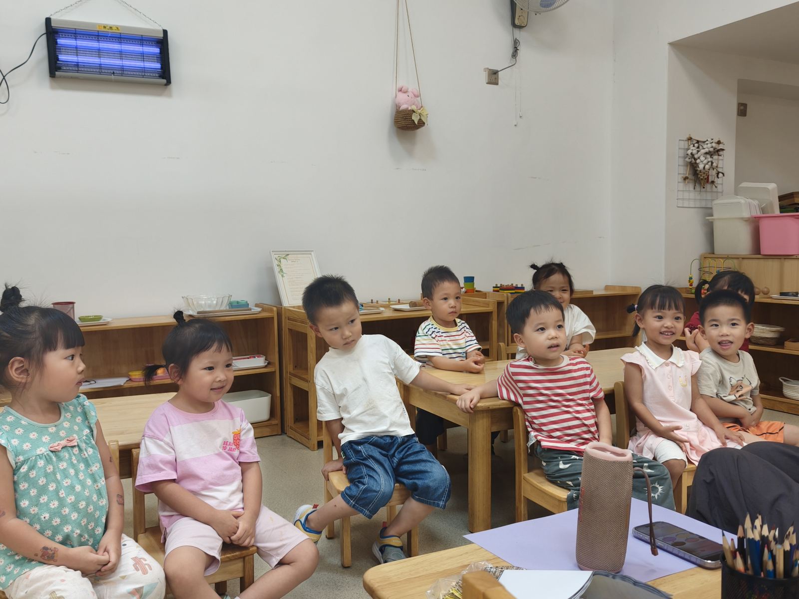 教室集体互动，孩子们围坐听老师讲解